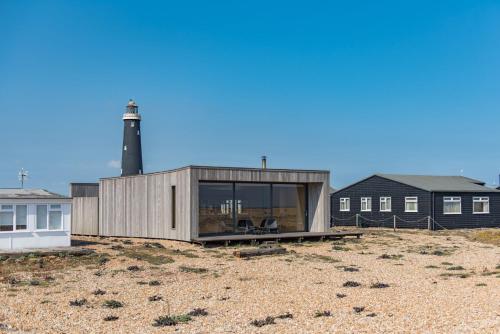 DungenessにあるEl Ray by Bloom Staysの灯台を背景にした家