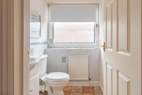 ein Bad mit einem weißen WC und einem Fenster in der Unterkunft The Landing in Hythe