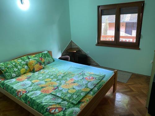 a bedroom with a bed with a colorful comforter on it at Konaci Nikola Banja Vrujci in Gornja Toplica