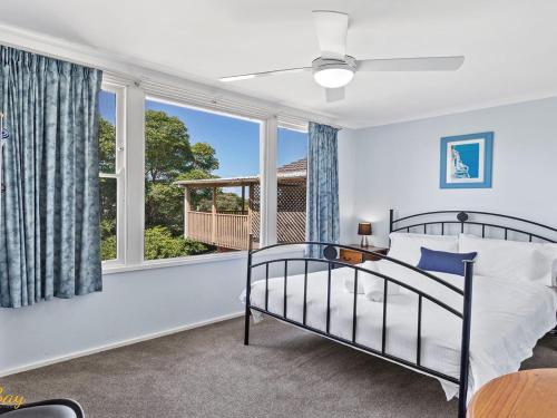 a bedroom with a bed and a large window at Lentara Street No 31 in Fingal Bay