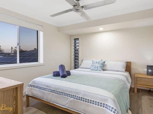 a bedroom with a bed with a ceiling fan at Twilight on Sunset Beach Soldiers Point in Soldiers Point
