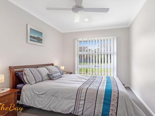 Un dormitorio con una cama y una ventana grande. en Scott Street Couples Getaway, en Anna Bay