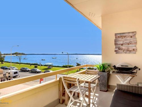 a balcony with a table and a view of the water at Bay Village No 7 Shoal Bay in Shoal Bay