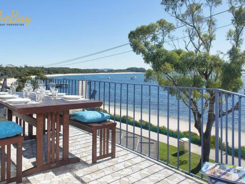 a table and chairs on a balcony with a view of the ocean at Shoal Towers No 9 in Shoal Bay