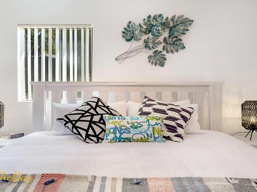 a bedroom with a white bed with pillows on it at Karinya at Little Beach Downstairs in Nelson Bay