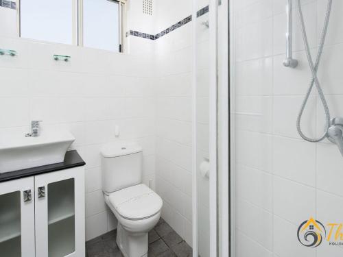 biała łazienka z toaletą i prysznicem w obiekcie Shoal Towers No 9 w mieście Shoal Bay