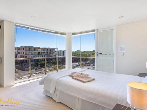 um quarto com uma cama grande e uma janela grande em Carrington No 4 Nelson Bay CBD em Nelson Bay