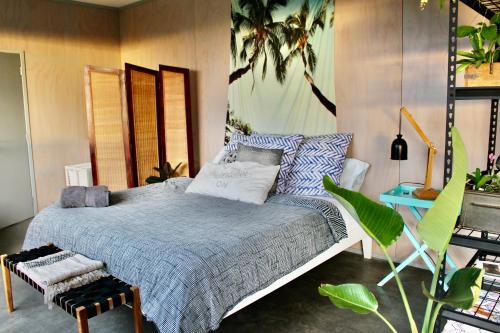a bedroom with a bed with a blue comforter at The Beach House on the Hill in Raglan