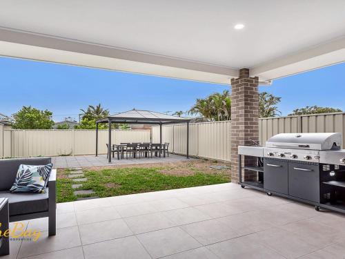 a patio with a grill and a table with a picnic table at Pacific Paradise No 28 Anna Bay in Anna Bay