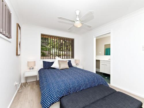 a bedroom with a bed and a ceiling fan at Fingal Escape 28 Bent St in Fingal Bay