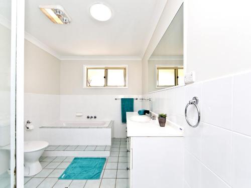 a white bathroom with a sink and a toilet at Fingal Escape 28 Bent St in Fingal Bay