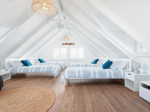 una sala de estar con 3 sofás en un ático en Kingsley Beach House Boat Harbour, en Anna Bay