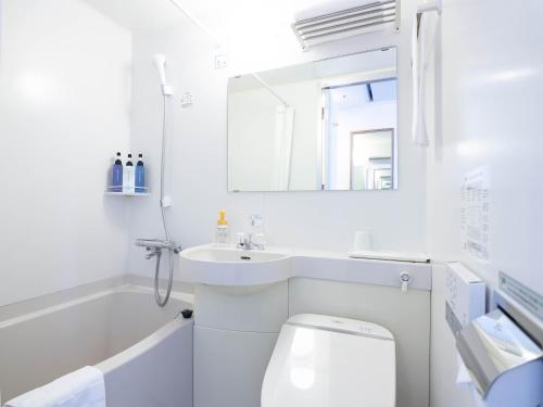 a white bathroom with a sink and a toilet at Hotel Belleview Nagasaki Dejima in Nagasaki