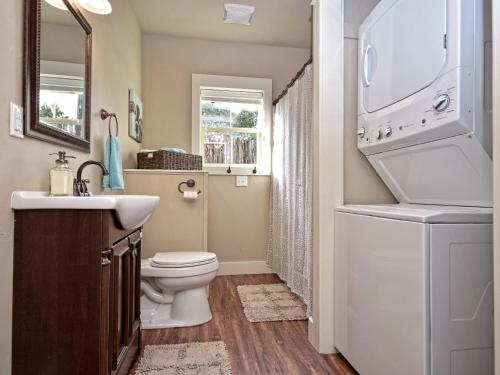 a bathroom with a toilet and a sink and a washer at Cabins at Flite Acres- Coyote Cabin in Wimberley