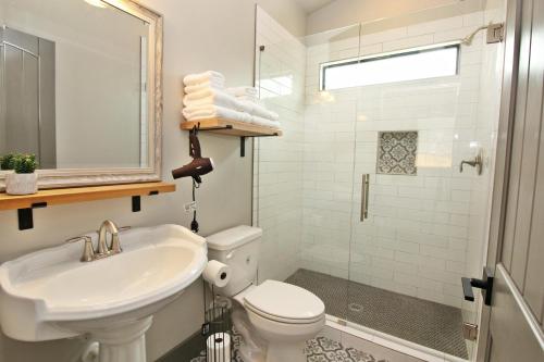 a bathroom with a sink and a toilet and a shower at Green Acres Cottages - Gruene Suite in Wimberley
