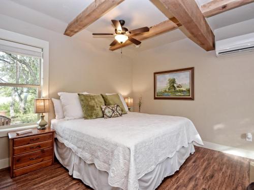 una camera con letto e ventilatore a soffitto di Cabins at Flite Acres-Mockingbird Cabin a Wimberley