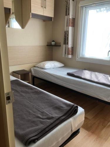 Ένα ή περισσότερα κρεβάτια σε δωμάτιο στο Mobilhome 2 Chambres 2 SDB