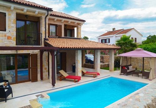 uma villa com piscina em frente a uma casa em Villa Berna - pool house em Malinska
