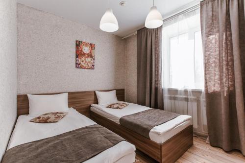 ein Hotelzimmer mit 2 Betten und einem Fenster in der Unterkunft Matreshka Hotel in Irkutsk