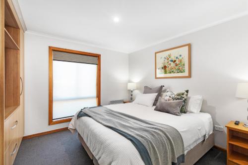 a bedroom with a large bed and a window at City Four Apartment in Mount Gambier