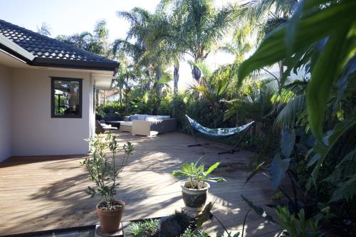 a patio with a hammock and some plants at Palm Garden Papamoa Beach Paradise in Papamoa