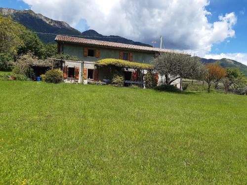 a house in a field with a green yard at Spacious Cottage in Veneto in Crespano del Grappa