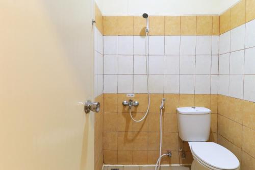 y baño con aseo y ducha. en Al-Badar Hotel Syariah Makassar en Makassar