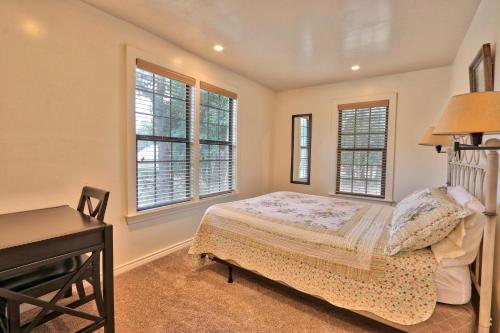 um quarto com uma cama, uma secretária e janelas em The Ranch at Wimberley - Caretaker's Cottage em Wimberley