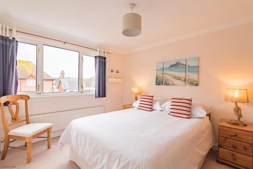 a bedroom with a bed and a chair and windows at The Landing in Hythe
