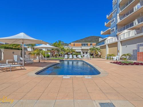a swimming pool in front of a building at Breakwater Apartment 205 in Shoal Bay