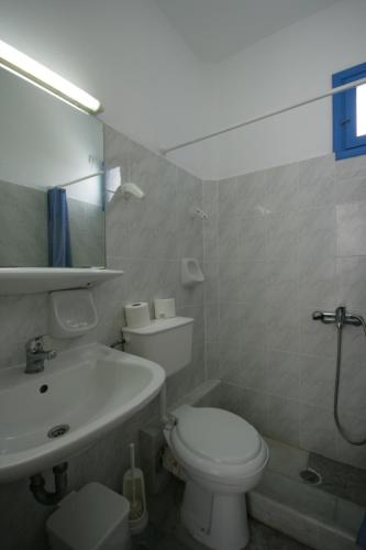 a bathroom with a white toilet and a sink at Sunny Beach Studios in Naxos Chora