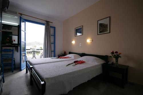 Un dormitorio con una cama con flores rojas. en Sunny Beach Studios, en Naxos Chora