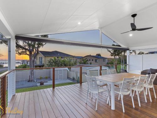 a wooden deck with a table and chairs on it at Twilight on Sunset Beach Soldiers Point in Soldiers Point