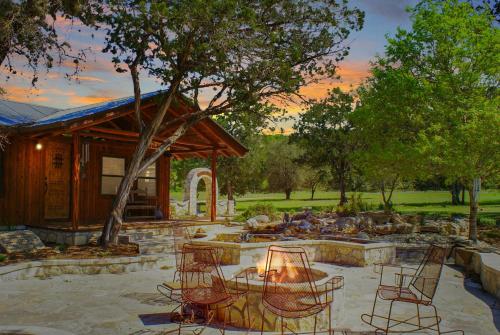 a patio with chairs and a fire pit in front of a house at Creekside Falls in Wimberley