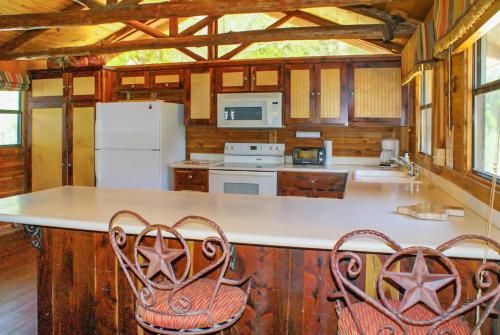 uma cozinha com um balcão com duas cadeiras em Creekside Falls em Wimberley