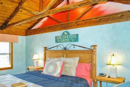 Un dormitorio con una cama y un techo de madera. en Creekside Falls, en Wimberley