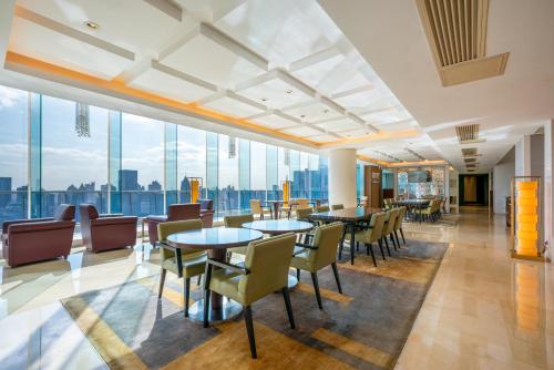 a restaurant with tables and chairs and large windows at The Eton Hotel Shanghai in Shanghai
