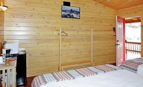 a bedroom with wooden walls and a bed in a room at Wimberley Log Cabins Resort and Suites- Unit 6 in Wimberley