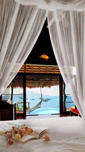 a bedroom with a bed with a view of the ocean at Koh Tao Cabana in Koh Tao