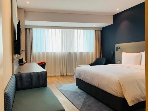 a hotel room with a bed and a sink at Holiday Inn Express Chongqing Airport Zone, an IHG Hotel in Chongqing