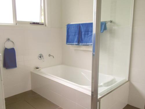 y baño con bañera blanca y toallas azules. en Riverside Retreat 544 Ocean Drive North Haven, en North Haven