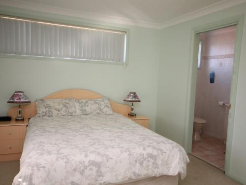 a bedroom with a large bed and a window at Pacific Breeze in Dunbogan