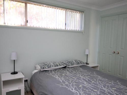 a bedroom with a bed and a window at Pacific Breeze in Dunbogan