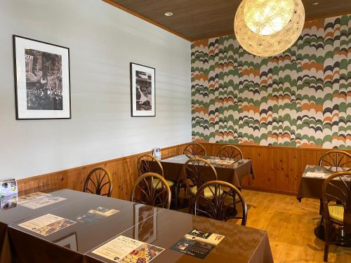 a dining room with tables and chairs and a floral wall at Kibi Kogen Resort Hotel in Kaga