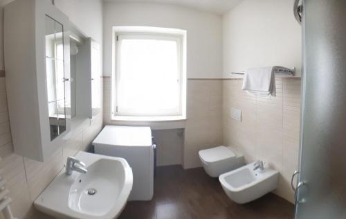 Baño blanco con lavabo y aseo en Asiago Millepini, en Asiago