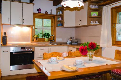 a kitchen with white cabinets and a wooden table at Wood house Irena-Počitniška hiša in Bohinj