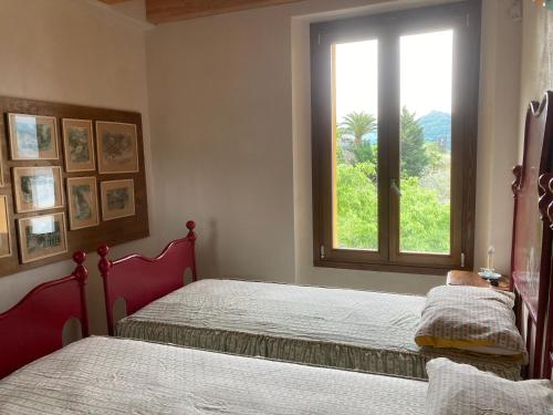 a bedroom with two beds and a window at CasaGialla in Marone