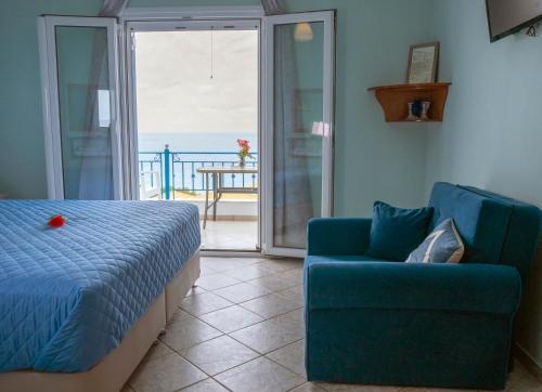 a bedroom with a bed and a couch and a balcony at Kaskanis Apartments in Vráchos