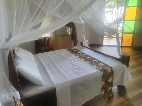 a bedroom with a bed with a canopy at Villa Kumi in Nungwi