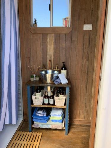 a shelf with bottles and baskets on it in a room at Evanston Station in Ilfracombe